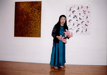 此次拍品（左）於藝術家的合照 台中臻品藝術中心，〈愛情核爆：萬劫後的草間彌生〉，1999年5月29日-6月27日 圖片和藝術品：© 草間彌生